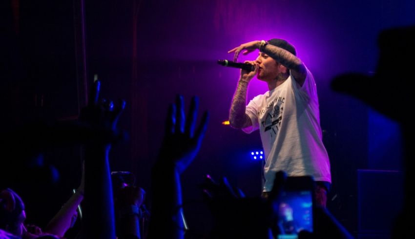 A man on stage with his hands up in the air.