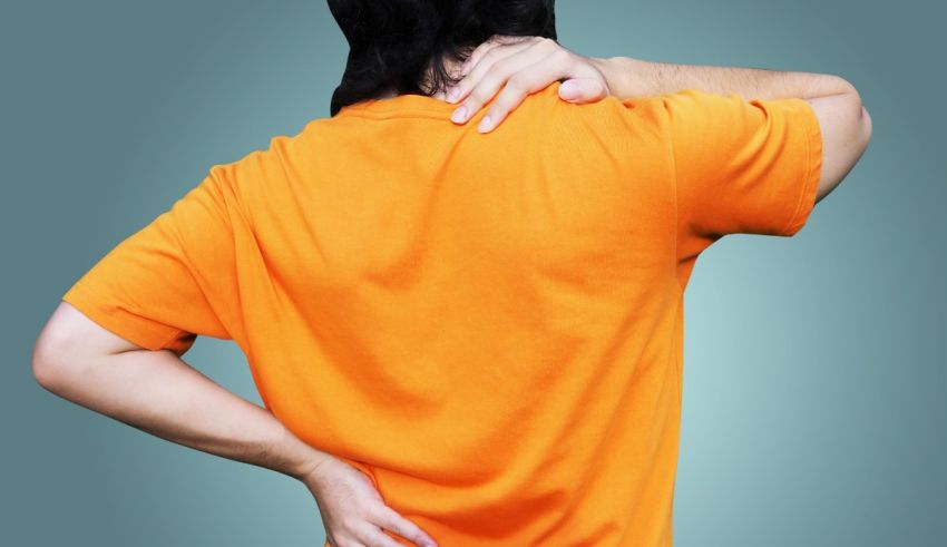 A man with a back pain in an orange shirt.