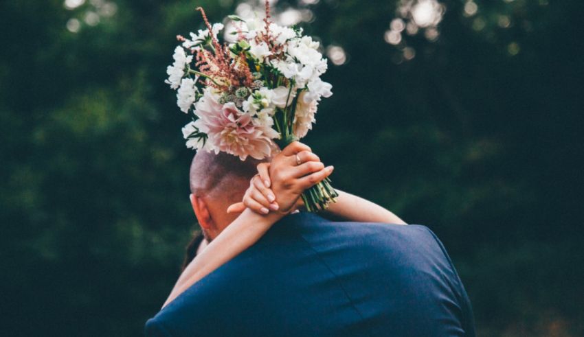 A bride is holding a bouquet of flowers on her head.