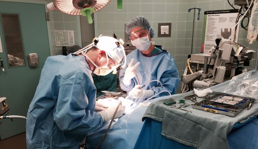 Two surgeons operating on a patient in an operating room.