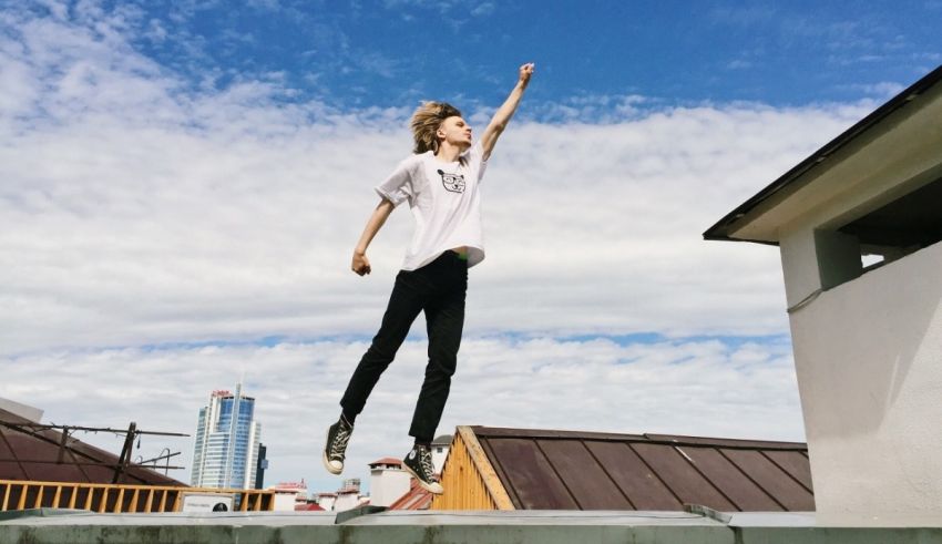 A young man jumping on top of a roof.
