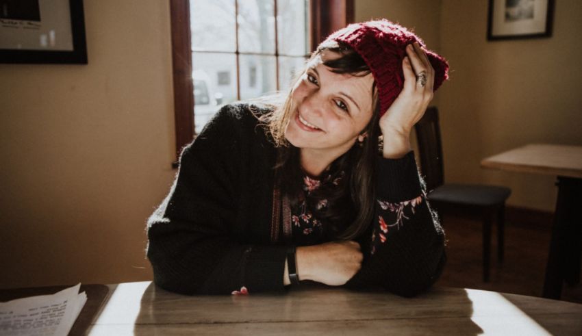 A woman wearing a beanie sitting at a table.