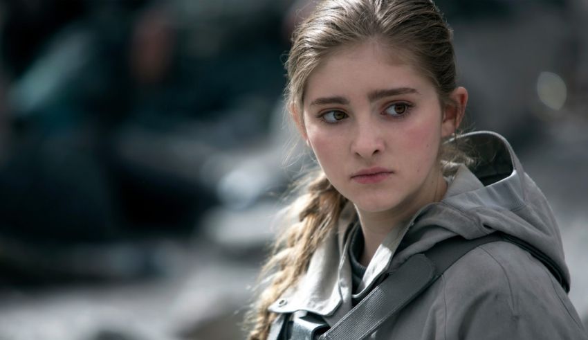A young girl in a gray hoodie is staring off into the distance.