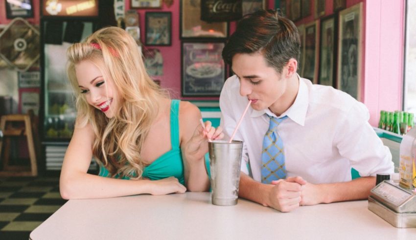 A young man and woman sitting at a table in a diner.