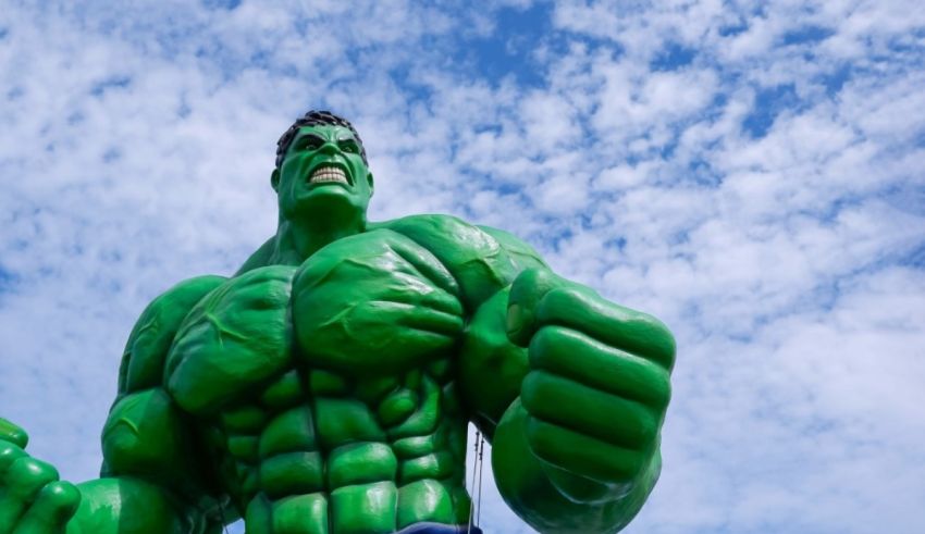 An incredible hulk statue in front of a blue sky.