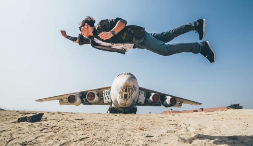 A man jumping in front of a plane.