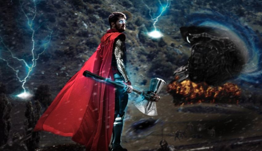 A man with a cape and a hammer is standing in front of a storm.