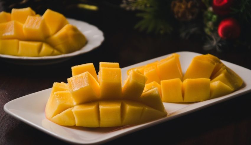 Two slices of mango on a white plate.