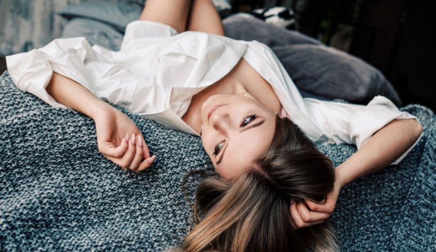 A young woman laying on a bed.