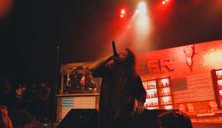 A man singing on stage at a concert.