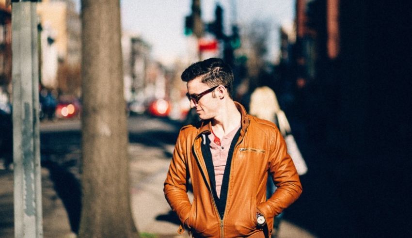 A man in a brown leather jacket walking down the street.