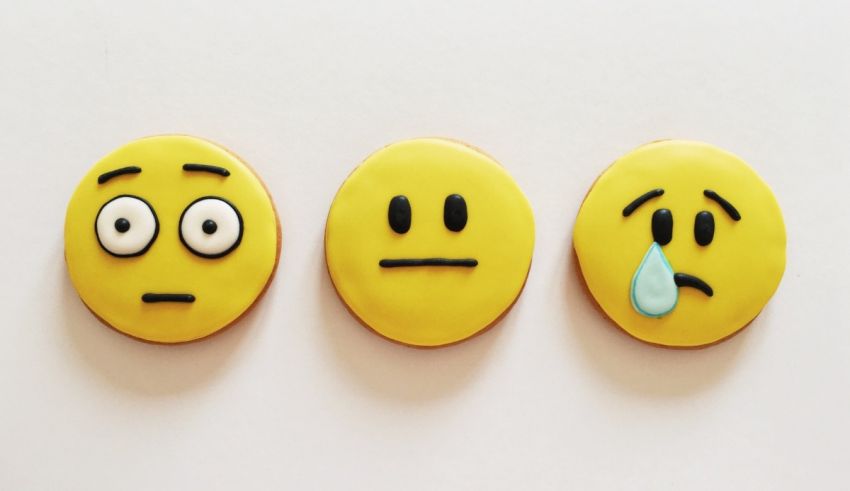 Three yellow emoticion cookies on a white background.