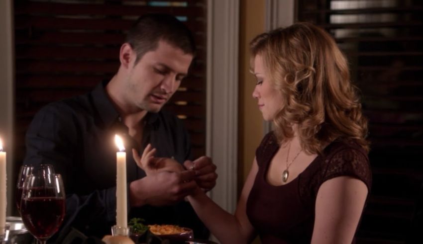 A man and woman sitting at a table with candles.