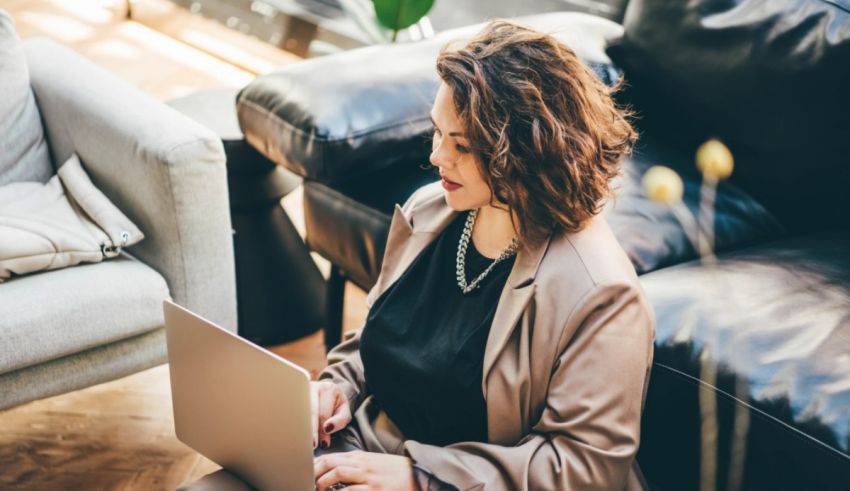 A woman sitting on a couch using a laptop.