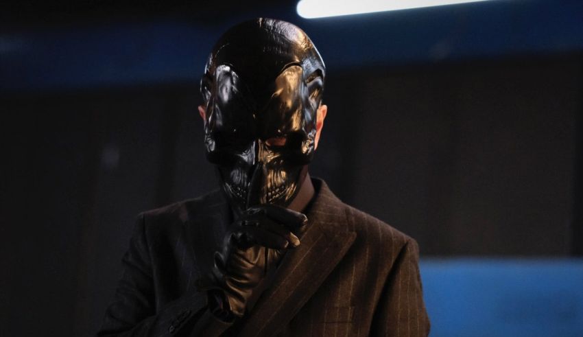 A man in a suit with a mask on his face.