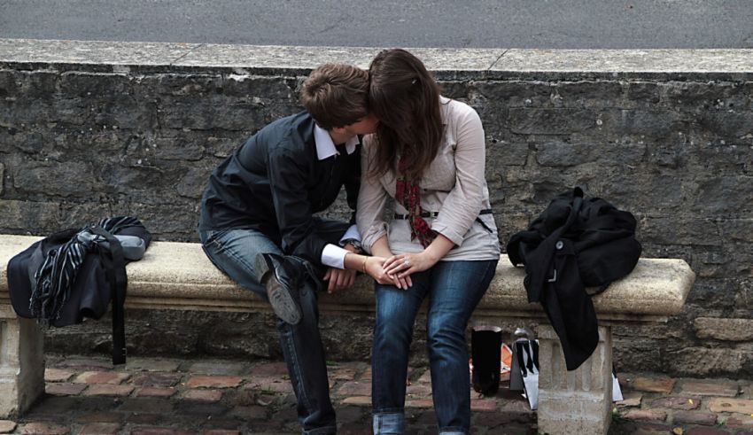 Two people sitting on a bench.