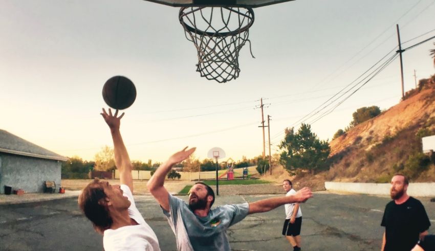 A group of people playing basketball on a street.
