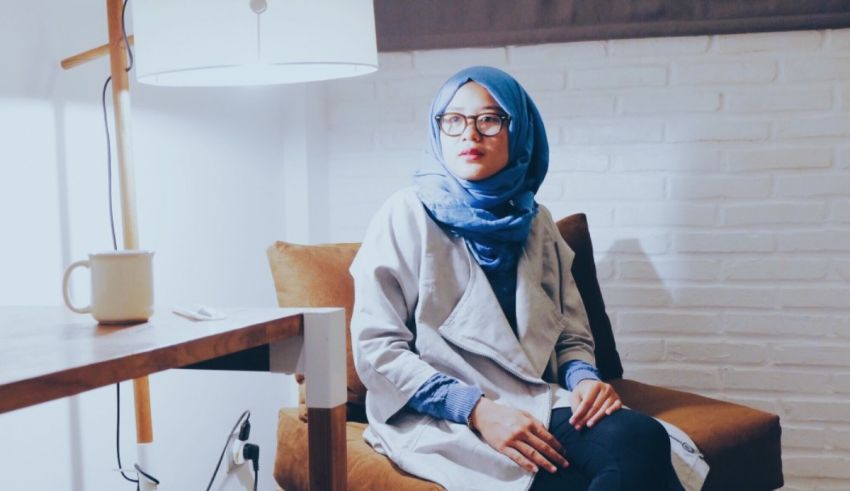 A muslim woman in hijab sitting on a chair.