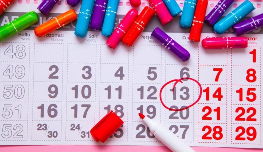 A calendar with colored pencils and a marker on it.