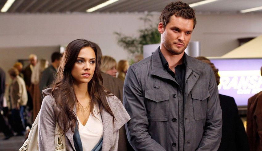 A man and woman standing next to each other in an airport.