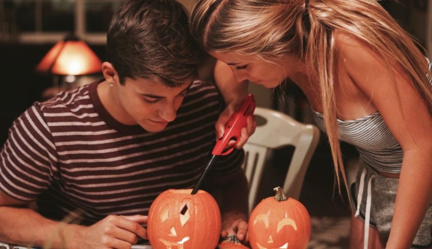A man and woman are carving pumpkins on a table.