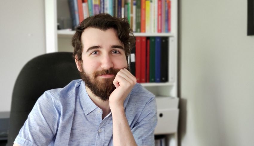 A man with a beard sitting at a desk.