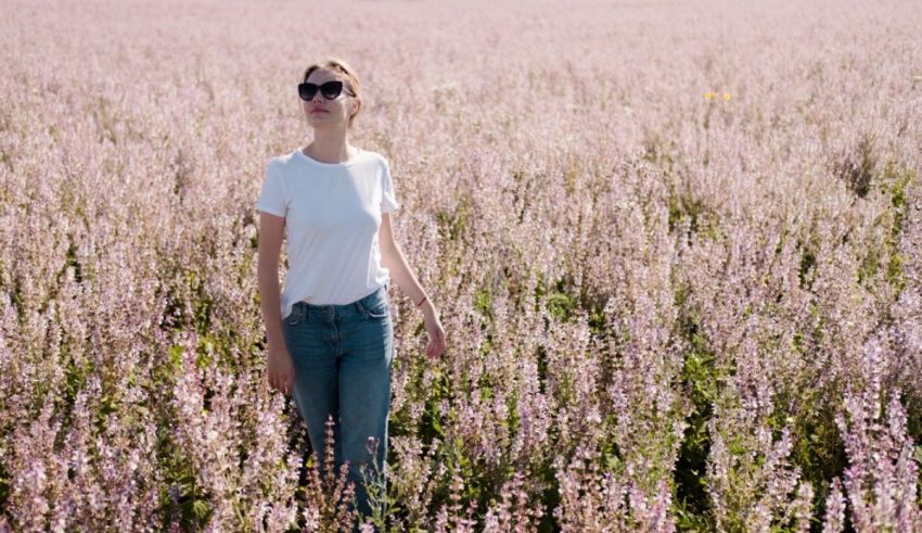 A woman is standing in a field of flowers.