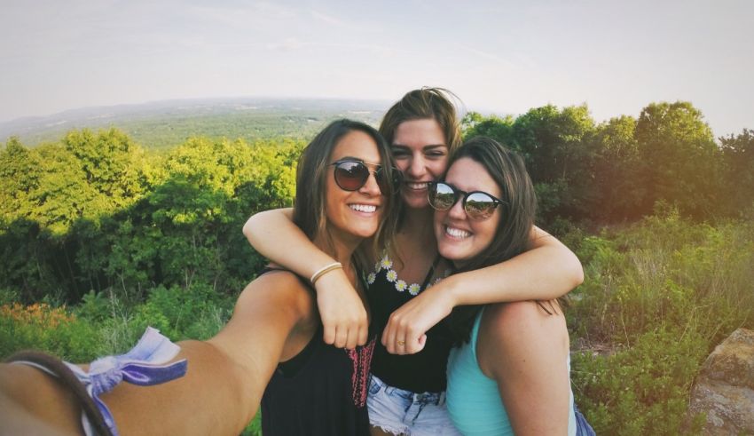 Three women taking a selfie on top of a hill.
