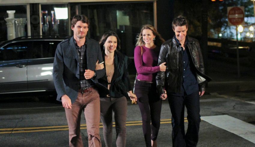 A group of people walking down the street at night.