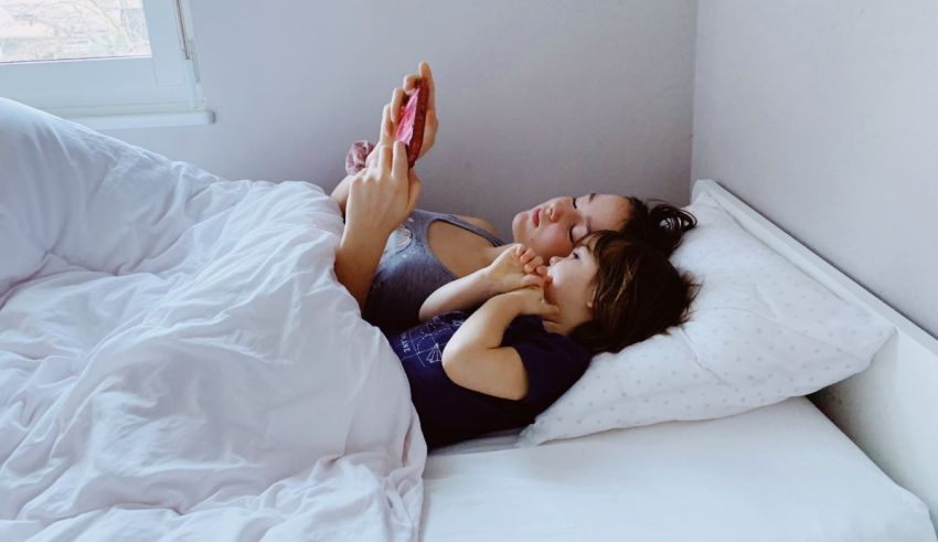 A mother and daughter reading a book in bed.