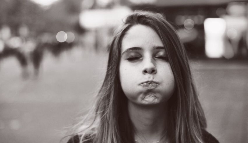 A black and white photo of a girl making a face.
