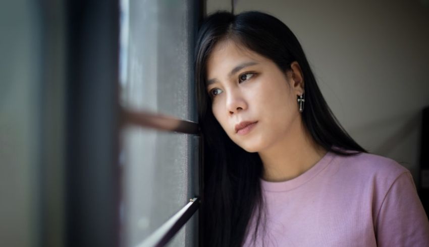 A young asian woman looking out a window.