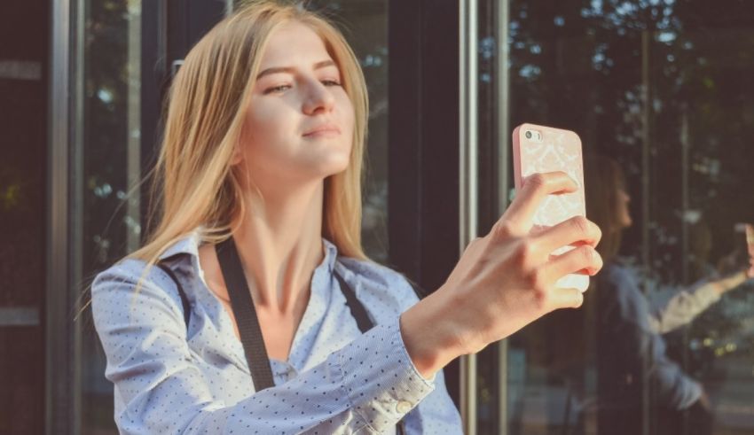 A woman is taking a selfie with her cell phone.