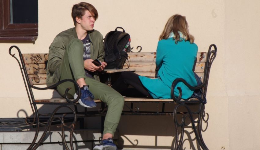 Two people sitting on a bench.