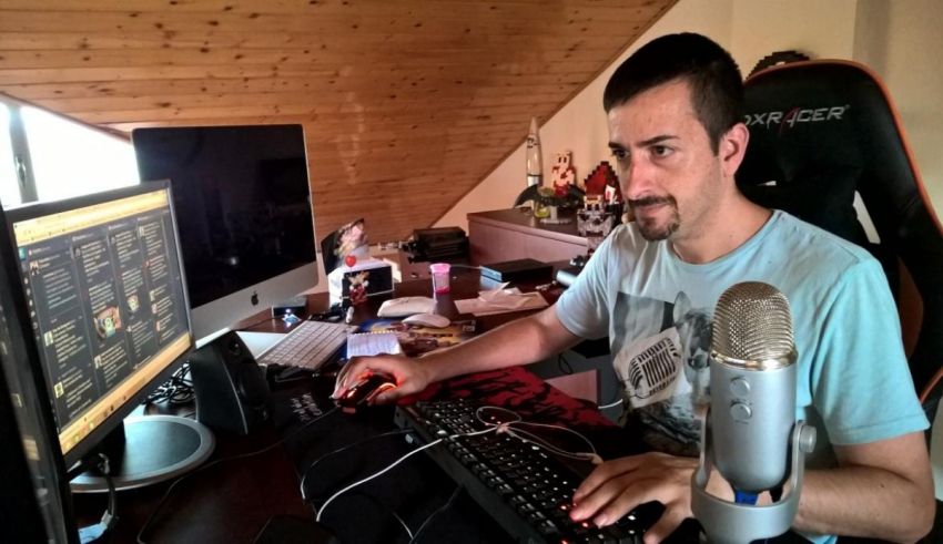 A man sitting at a desk with a microphone in front of him.