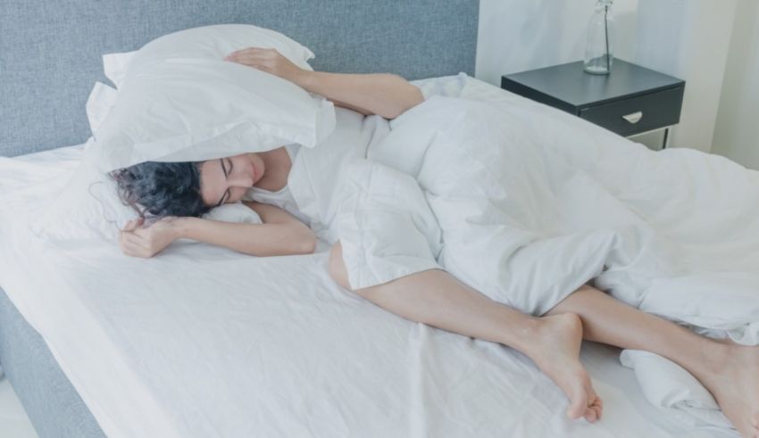 A woman sleeping in a bed with white sheets.