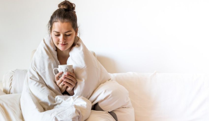 A woman sitting on a couch holding a cup.