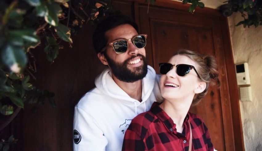 A man and woman smiling in front of a door.