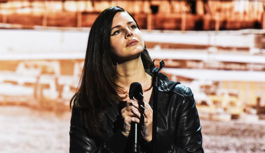 A woman in a leather jacket is holding a microphone.