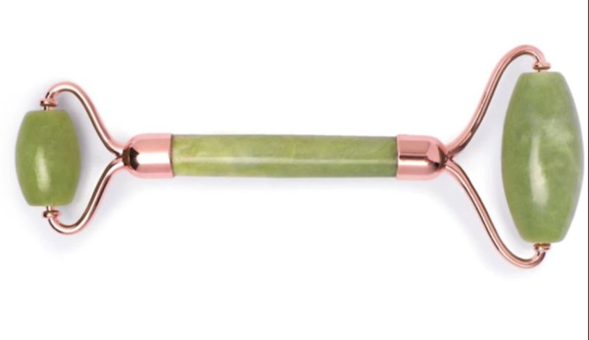 A green jade roller on a white background.