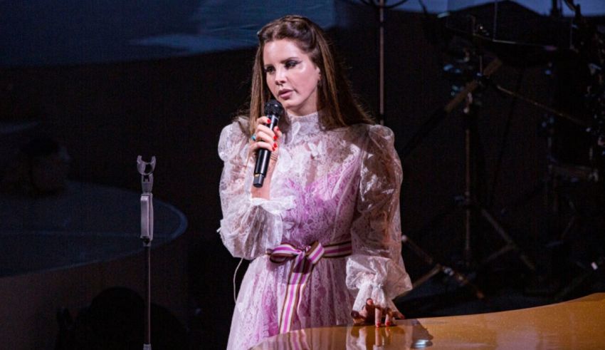 A woman in a pink dress singing into a microphone.