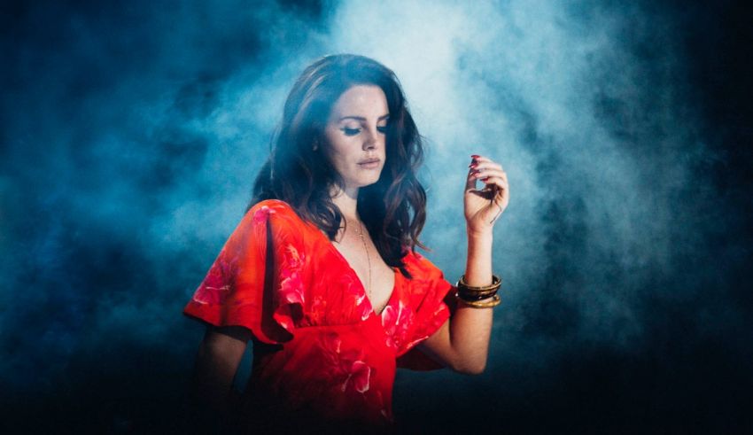 A woman in a red dress smokes a cigarette.