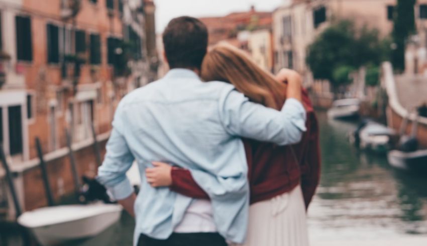 A couple hugging in front of a canal in venice.