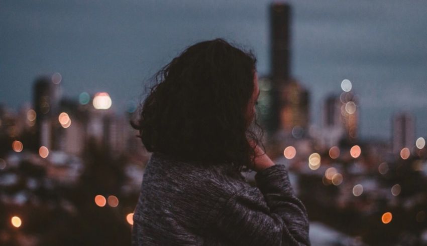 A woman looking out over a city at night.