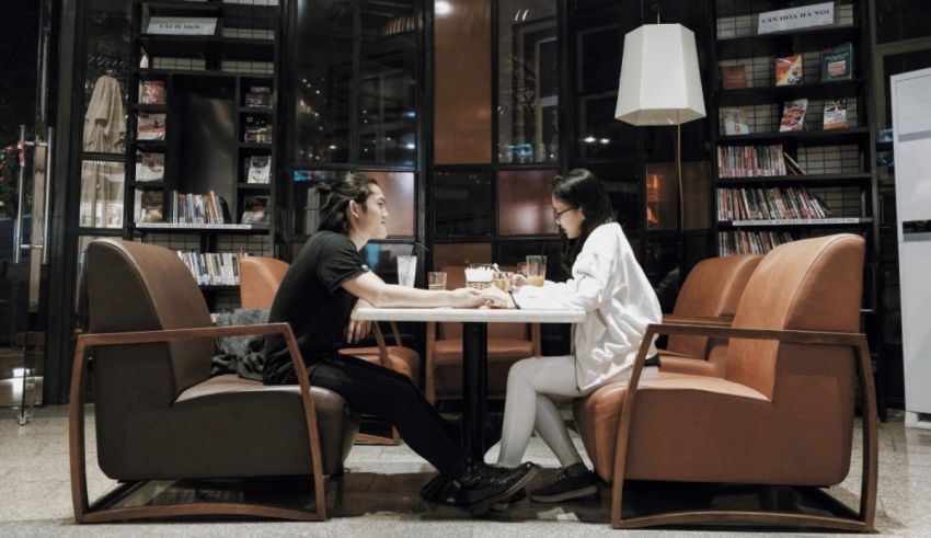 Two women sitting at a table in a library.