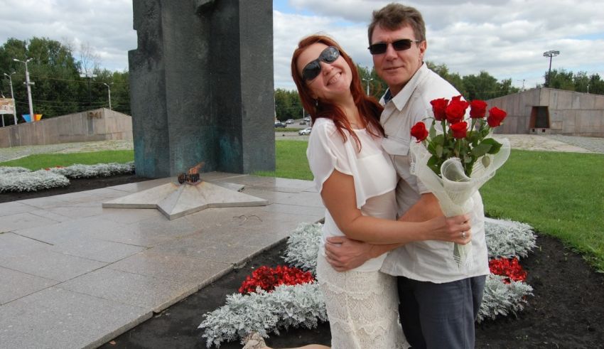 A man and woman posing for a picture in front of a monument.