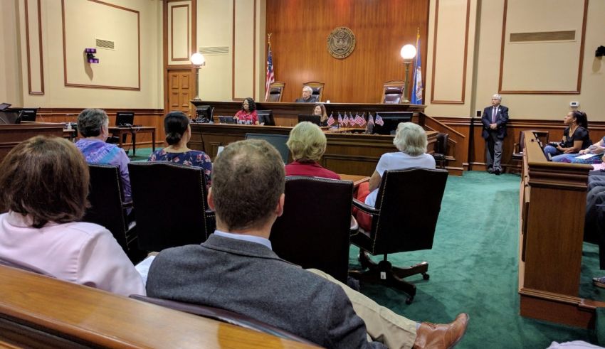 A group of people sitting in a courtroom.