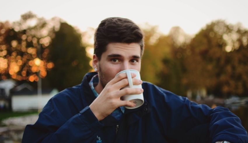 A young man drinking a cup of coffee.