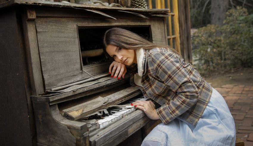 A woman is leaning on an old piano.