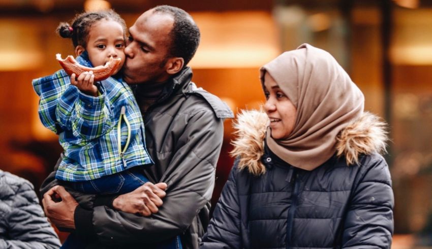 A family with a child in a hijab holding a doughnut.